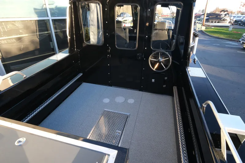 Slide: The Image of 2025 Hewescraft 220 Ocean Pro ET HT boat interior with steering wheel and spacious deck. - 7