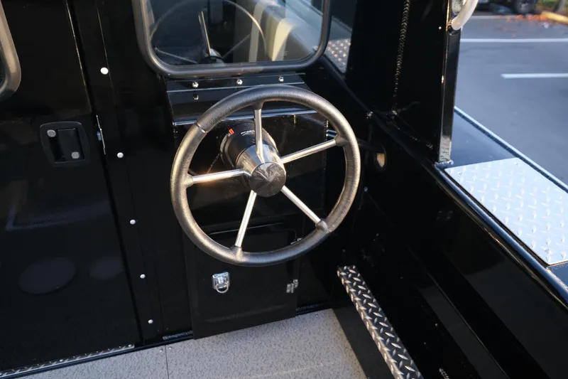 Slide: The Image of Steering wheel of 2025 Hewescraft 220 Ocean Pro ET HT boat, featuring sleek black interior. - 8