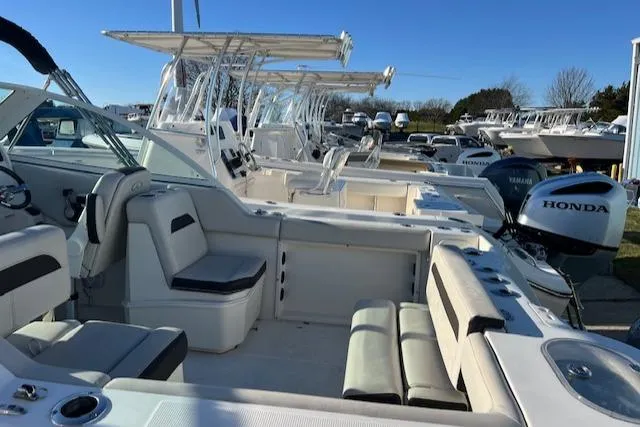 Slide: The Image of 2021 Sailfish 245 DC boat with Honda outboard motor, docked in a marina. - 10