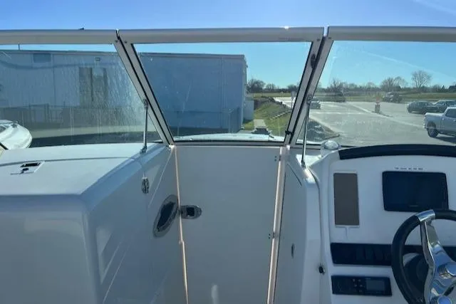 Slide: The Image of 2021 Sailfish 245 DC boat interior with steering wheel and windshield view. - 5
