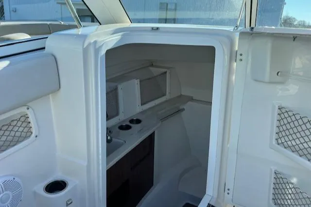 Slide: The Image of Interior cabin of 2021 Sailfish 245 DC boat, featuring compact amenities and storage. - 6
