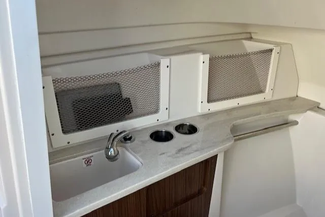 Slide: The Image of 2021 Sailfish 245 DC boat interior with sink and storage compartments. - 7
