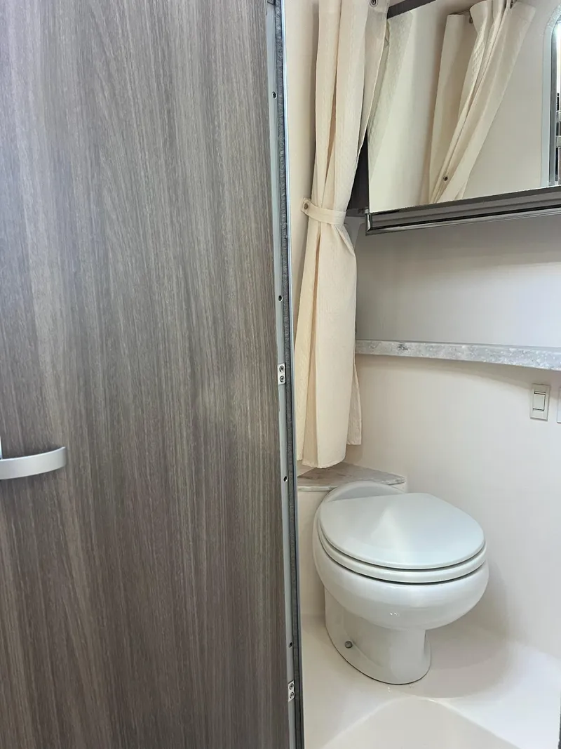 Slide: The Image of 2020 Regal Express bathroom with modern design, featuring a toilet and shower curtain. - 14