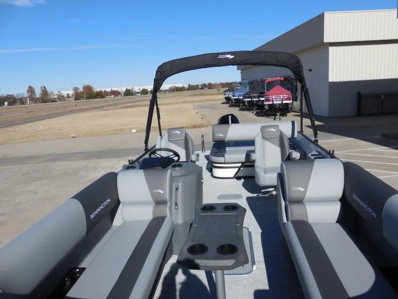 Slide: The Image of 2025 Bennington 23 SSB pontoon boat with gray seating and canopy, parked outdoors. - 5