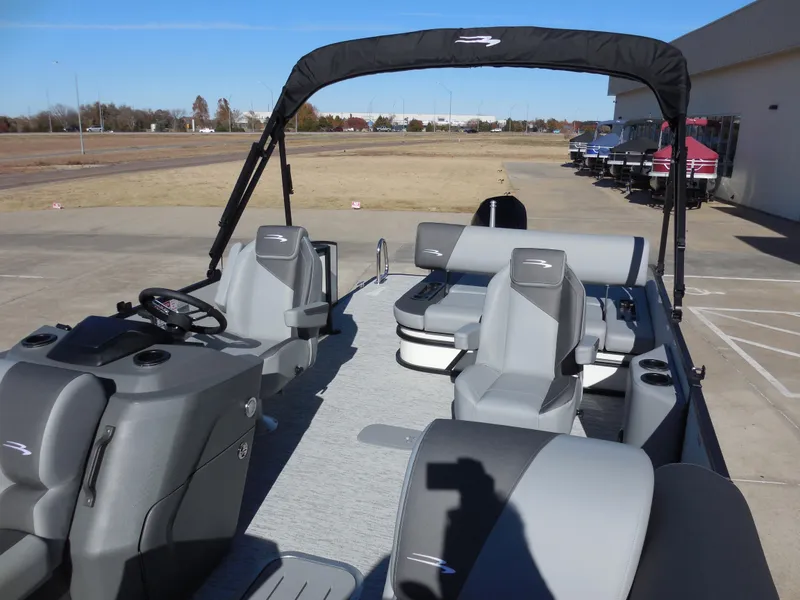 Slide: The Image of 2025 Bennington 23 SSB pontoon boat with gray seating and canopy, parked outdoors. - 6