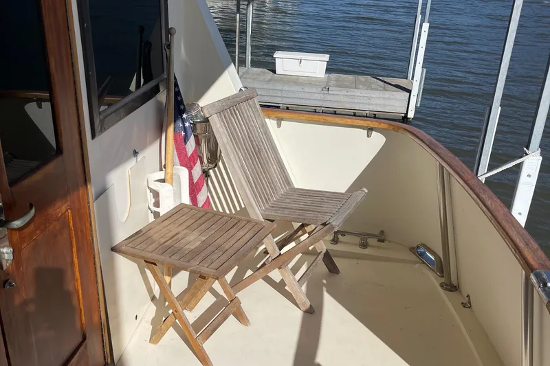 Slide: The Image of Wooden deck chairs on 1984 Hatteras 53 Motor Yacht, overlooking water. - 14