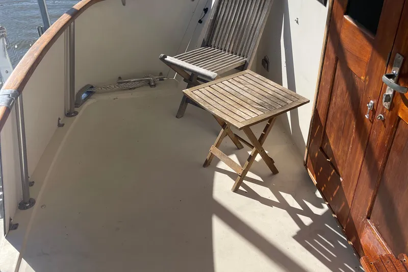 Slide: The Image of 1984 Hatteras 53 Motor Yacht deck with wooden chair and table. - 16