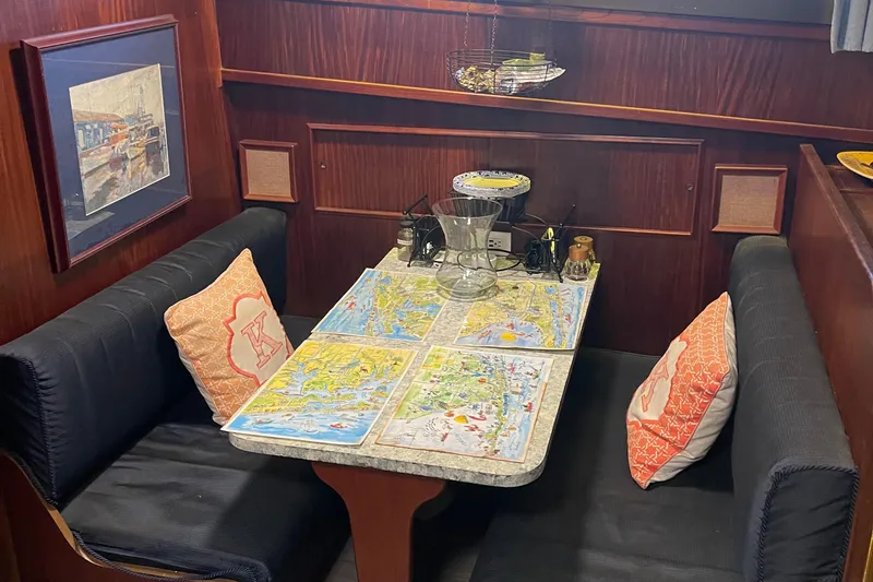 Slide: The Image of Cozy dining area in 1984 Hatteras 53 Motor Yacht with nautical decor and maps. - 18