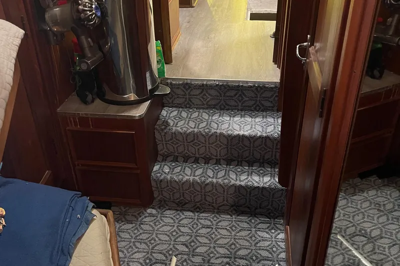 Slide: The Image of Interior of 1984 Hatteras 53 Motor Yacht with carpeted stairs and wood paneling. - 23