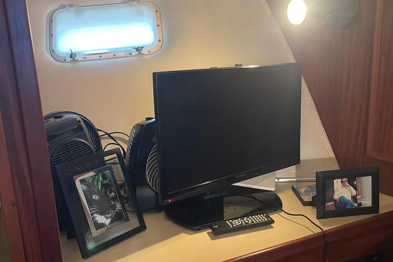 Slide: The Image of Interior of 1984 Hatteras 53 Yacht with TV, framed photos, and porthole window. - 25