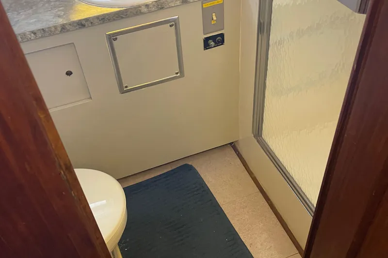 Slide: The Image of 1984 Hatteras 53 Motor Yacht bathroom with shower, toilet, and blue mat. - 26