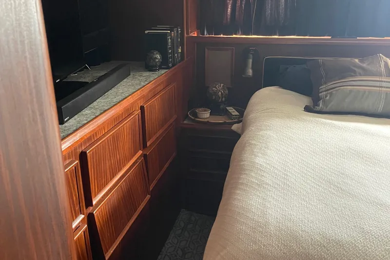 Slide: The Image of Cozy bedroom in 1984 Hatteras 53 Motor Yacht with wood paneling and soft lighting. - 36