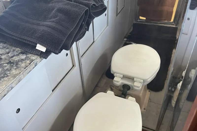 Slide: The Image of Bathroom interior of 1984 Hatteras 53 Motor Yacht with dual toilets and black towels. - 46