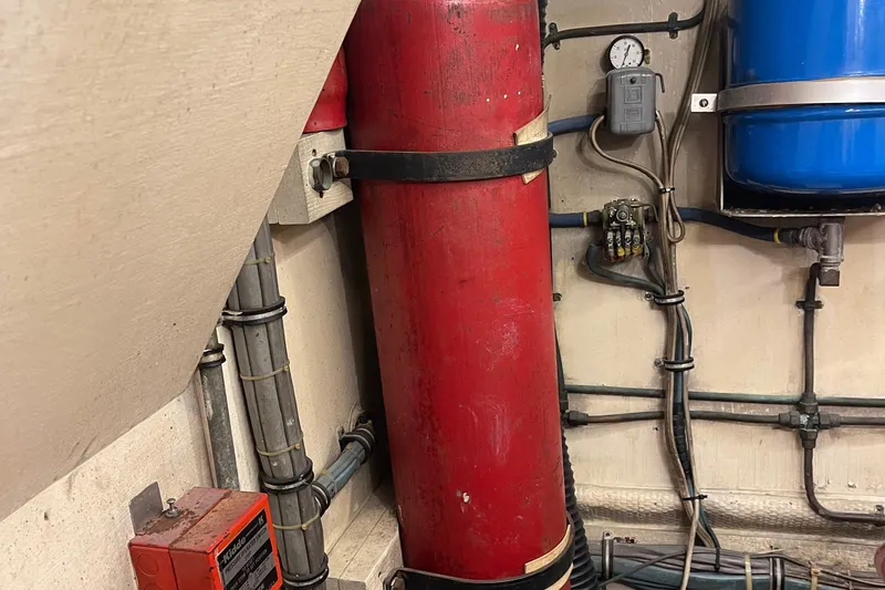 Slide: The Image of Engine room of 1984 Hatteras 53 Motor Yacht with red cylinder and wiring. - 48