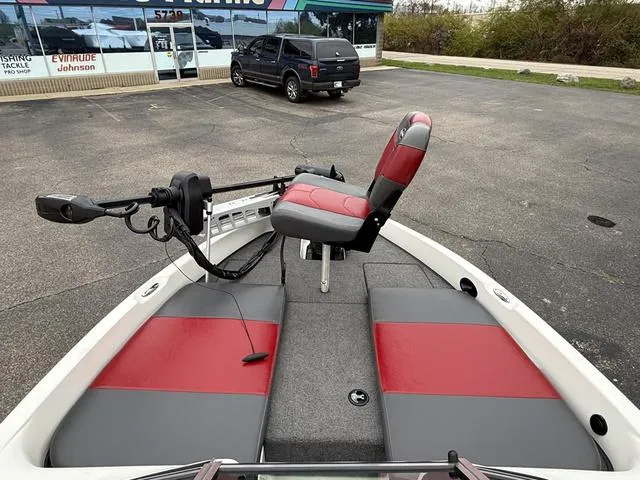 Slide: The Image of 2014 Triton 220 Escape boat with red and gray seating, parked in a lot. - 3