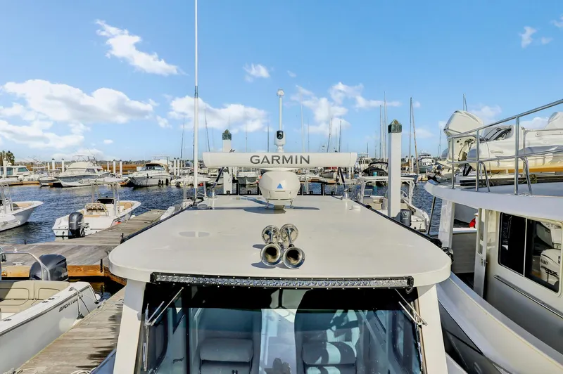 Slide: The Image of 2024 Custom Nerowalker boat docked at marina with Garmin equipment, clear sky background. - 21