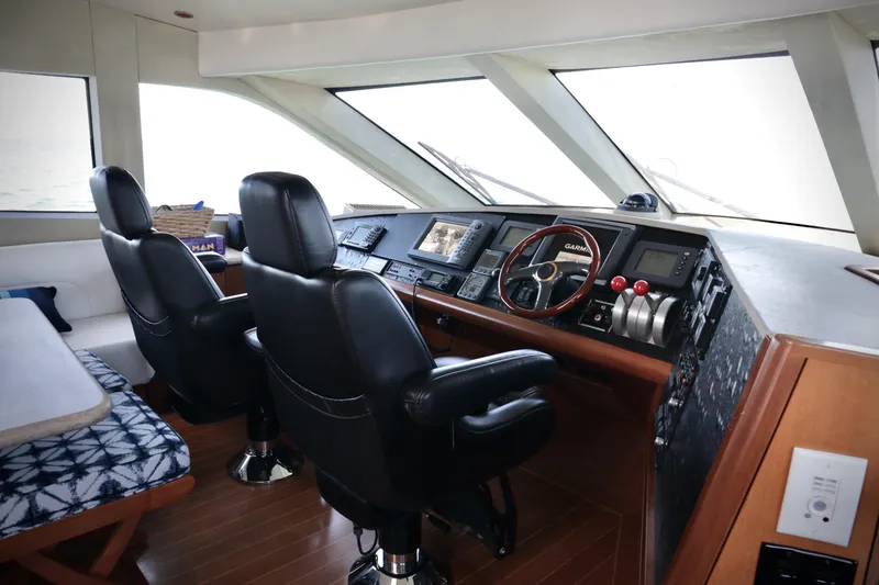 Slide: The Image of 2003 Hatteras 6300 Motor Yacht helm with leather seats and modern navigation equipment. - 13