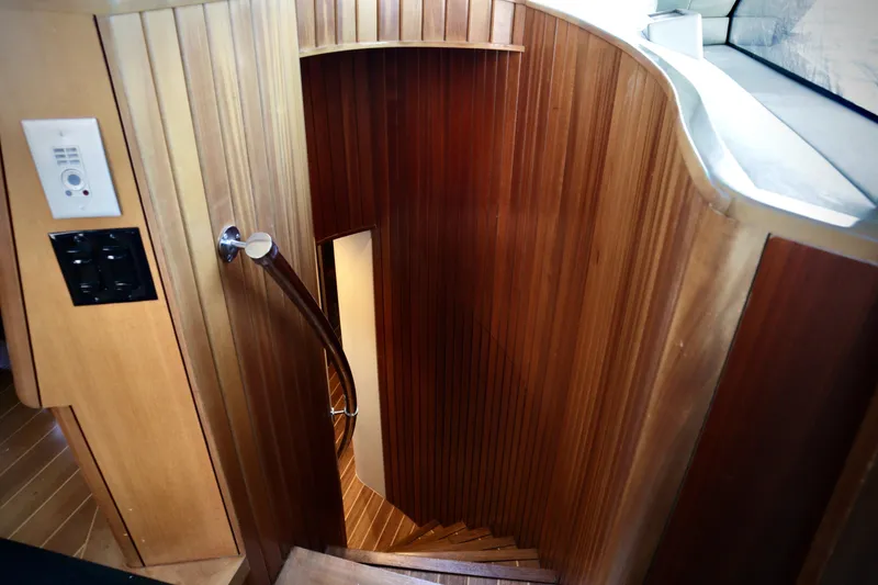 Slide: The Image of Wooden spiral staircase inside 2003 Hatteras 6300 Motor Yacht, featuring elegant design and craftsmanship. - 21
