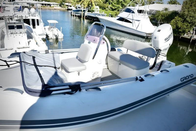 Slide: The Image of 2003 Hatteras 6300 Motor Yacht with inflatable tender on deck, docked at marina. - 27