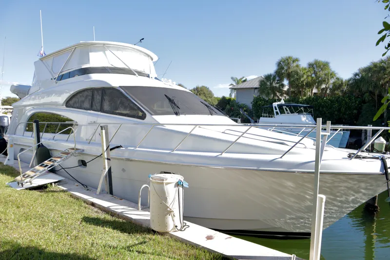 Slide: The Image of 2003 Hatteras 6300 Motor Yacht docked, featuring sleek design and spacious upper deck. - 4