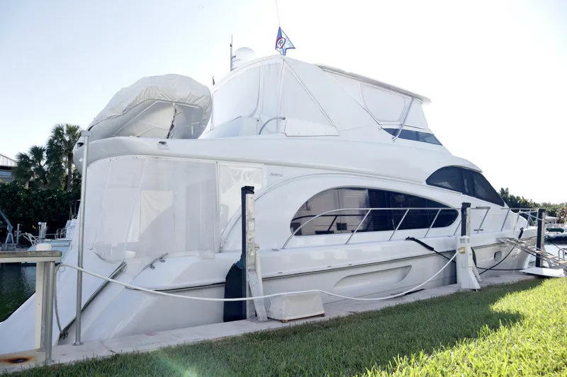 Slide: The Image of 2003 Hatteras 6300 Motor Yacht docked, featuring sleek design and spacious deck. - 5