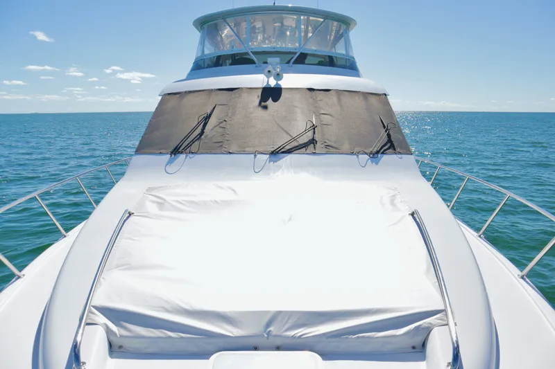 Slide: The Image of 2003 Hatteras 6300 Motor Yacht on open sea, showcasing sleek design and spacious deck. - 6