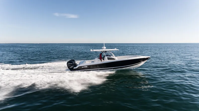 Slide: The Image of 2025 Nor-Tech 340 boat speeding on open water under clear blue sky. - 14