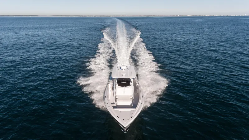 Slide: The Image of 2025 Nor-Tech 340 boat cruising on open water, aerial view. - 19