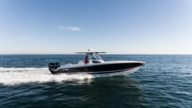 Slide: The Image of 2025 Nor-Tech 340 boat cruising on open water under clear skies. - 2