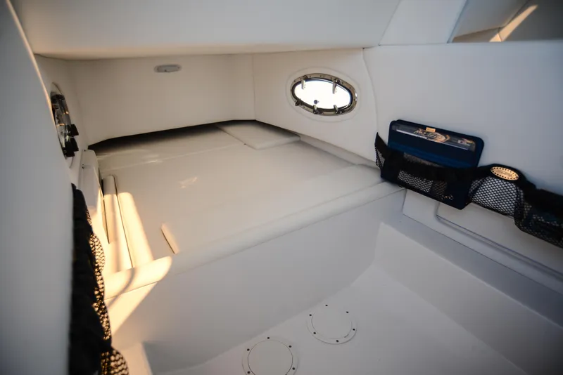 Slide: The Image of Interior cabin of 2025 Nor-Tech 340 boat, featuring white seating and storage compartments. - 26