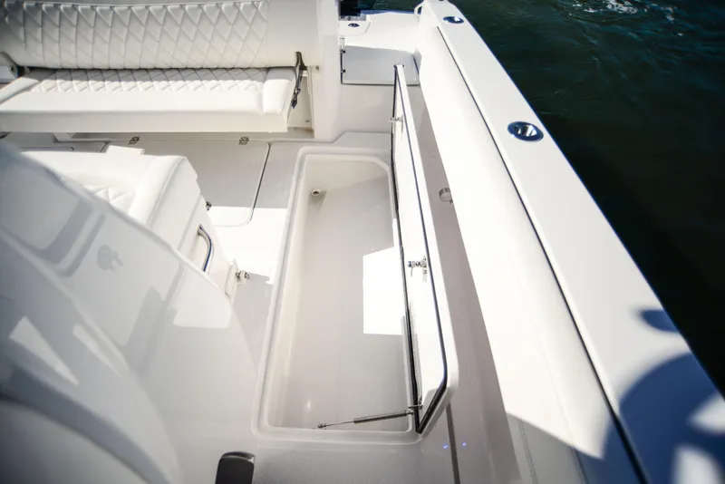 Slide: The Image of 2025 Nor-Tech 340 boat interior with open storage compartment and cushioned seating. - 46