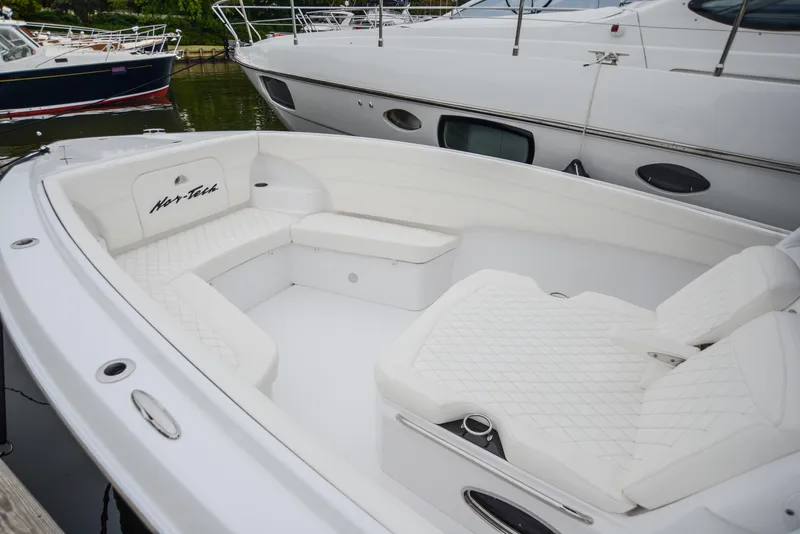 Slide: The Image of 2025 Nor-Tech 340 boat with spacious white seating area in marina. - 6