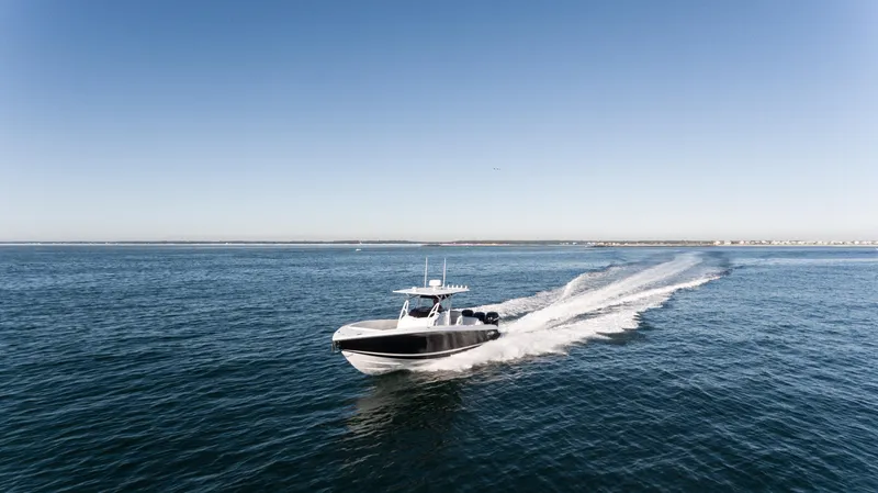 Slide: The Image of 2025 Nor-Tech 340 boat cruising on open water under clear blue sky. - 8