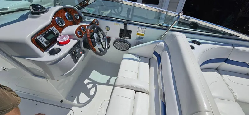 Slide: The Image of 2004 Formula 260 Bowrider boat interior with white seating and wood-accented dashboard. - 11