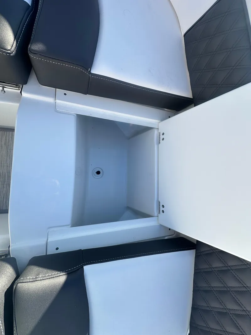 Slide: The Image of 2025 Monterey M-45 boat seating with storage compartment, featuring black and white upholstery. - 27