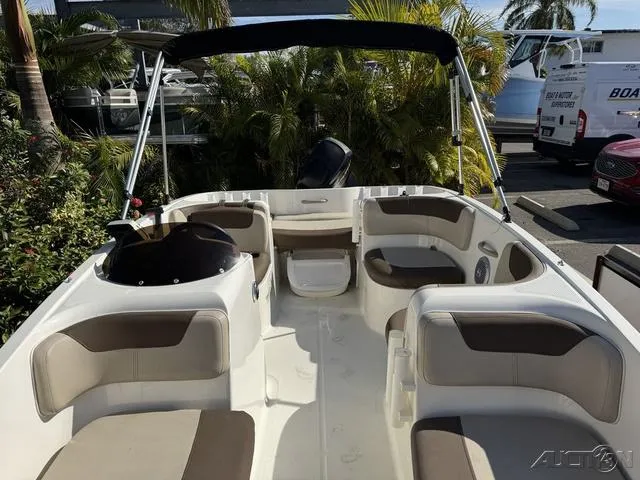Slide: The Image of 2014 Bayliner 160 Bowrider interior with seating, canopy, and tropical background. - 23