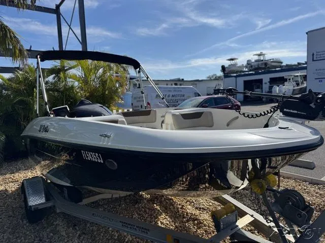 Slide: The Image of 2014 Bayliner 160 Bowrider boat on trailer, parked outdoors. - 4