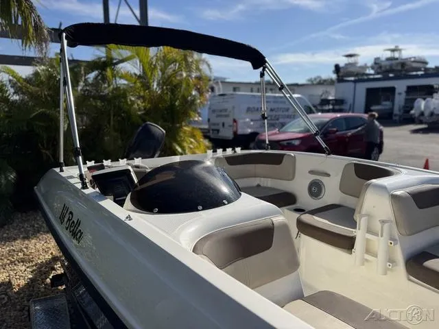Slide: The Image of 2014 Bayliner 160 Bowrider boat with seating, parked outdoors near palm trees. - 6
