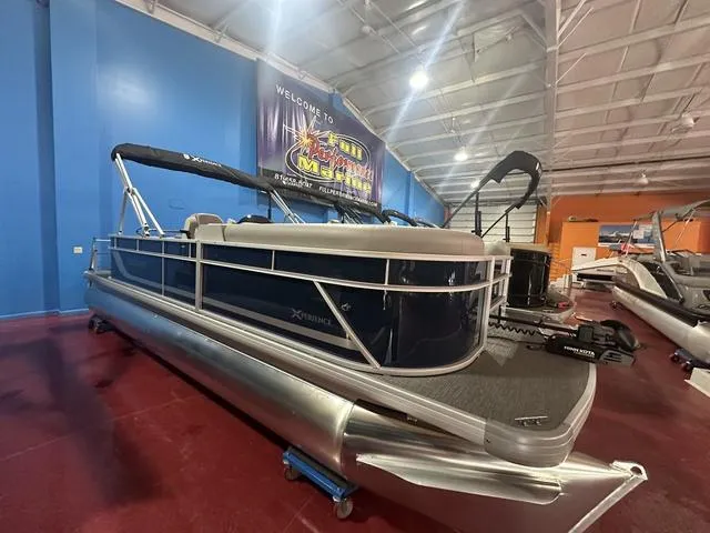 Slide: The Image of 2025 Godfrey Pontoons Xperience 2286 FSX in showroom, blue exterior, modern design. - 1