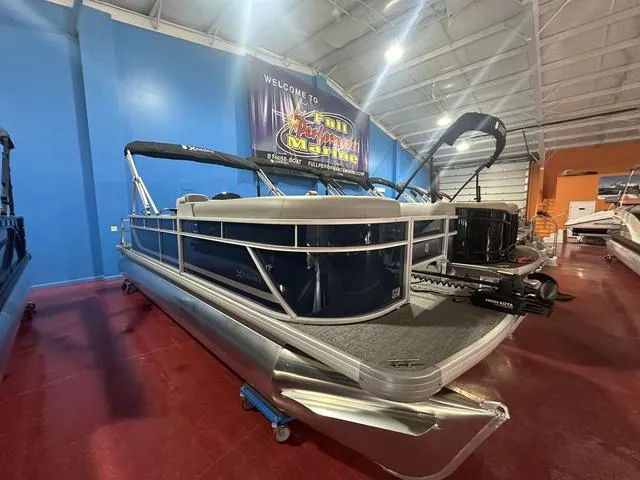 Slide: The Image of 2025 Godfrey Pontoons Xperience 2286 FSX in showroom, blue exterior, modern design. - 2