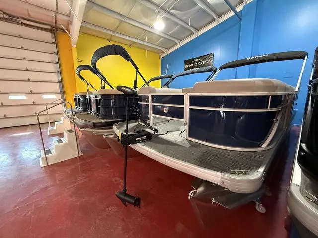 Slide: The Image of 2025 Godfrey Pontoons Xperience 2286 FSX in showroom, blue and silver design. - 5