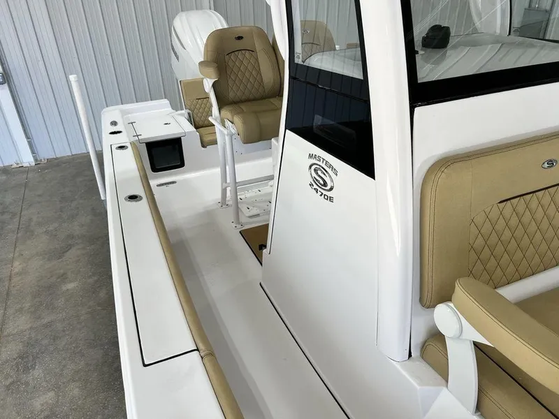 Slide: The Image of 2025 Sportsman Masters 247OE Bay Boat interior with tan seating and white console. - 10