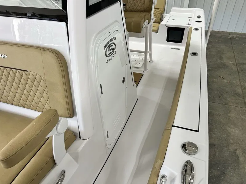 Slide: The Image of 2025 Sportsman Masters 247OE Bay Boat interior with tan cushioned seating. - 11