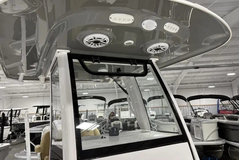 Slide: The Image of 2025 Sportsman Masters 247OE Bay Boat in showroom, featuring tan seating and modern design. - 29