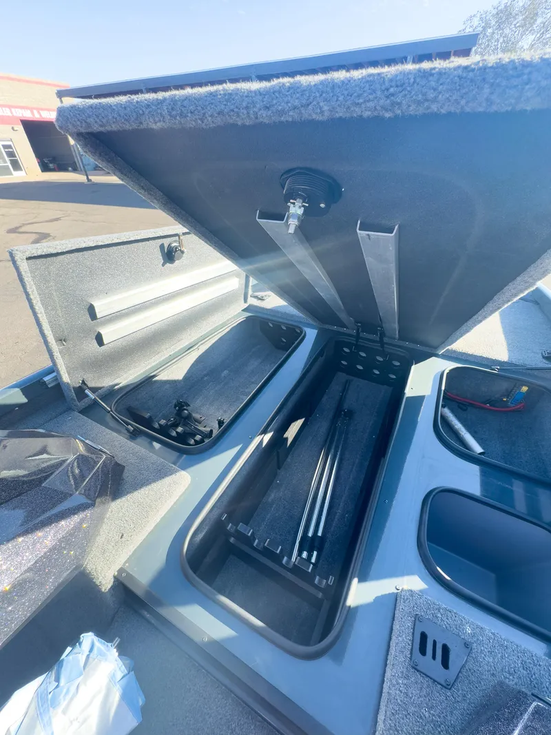 Slide: The Image of 2023 Ranger RT198P boat storage compartments open under sunny sky. - 2