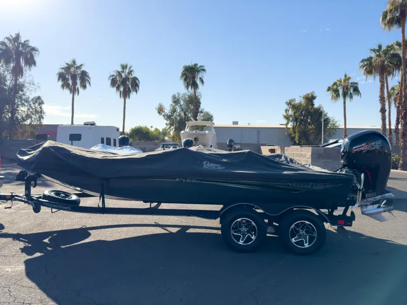 Slide: The Image of 2023 Ranger RT198P boat covered on trailer, parked outdoors with palm trees. - 8
