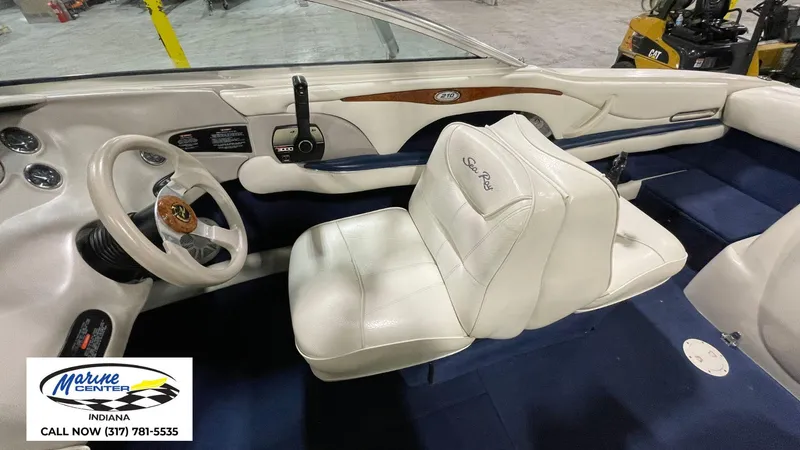 Slide: The Image of Interior of a 2000 Sea Ray 210 BR boat with white seating and steering wheel. - 11