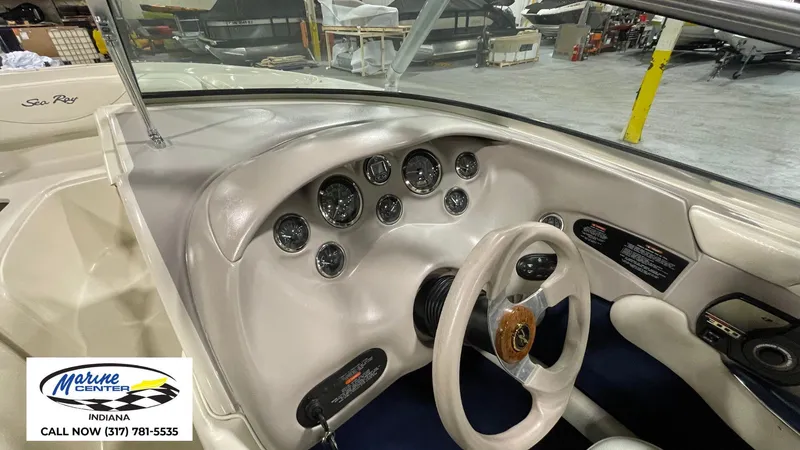 Slide: The Image of Interior dashboard of a 2000 Sea Ray 210 BR boat, featuring gauges and steering wheel. - 19