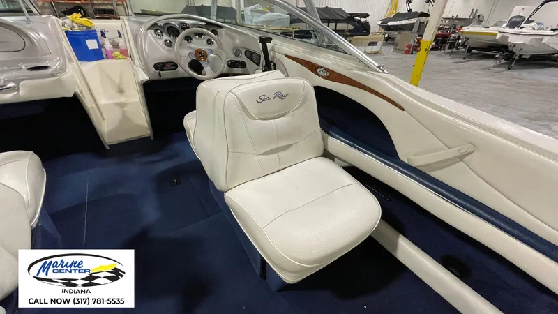Slide: The Image of Interior of a 2000 Sea Ray 210 BR boat with white seating and dashboard. - 4
