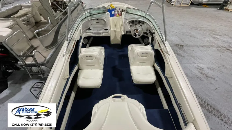 Slide: The Image of 2000 Sea Ray 210 BR boat interior with white seats and dashboard, displayed at Marine Center. - 6